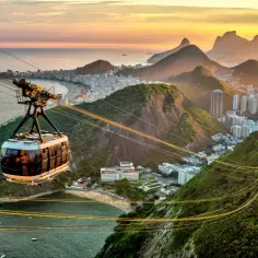 Widok z kolejki linowej na Rio de Janeiro o zachodzie słońca. Czy Brazylia jest bezpieczna? Turyści podziwiają panoramę miasta i oceanu.