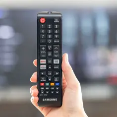 Pilot Samsung w dłoni, gotowy do ustawienia telewizji naziemnej.
