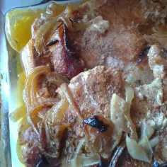 Schab pieczony w piekarniku w naczyniu, z cebulą i przyprawami. Mięso jest soczyste i rumiane.