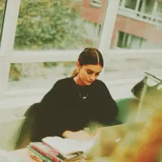 Młoda kobieta uczy się przy laptopie. Kryminologia otwiera drzwi do kariery w policji, sądownictwie, czy analizie kryminalnej.