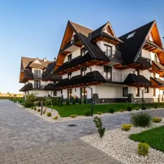 Nowoczesne apartamenty w Białce Tatrzańskiej, gdzie słońce oświetla śnieżne szczyty.