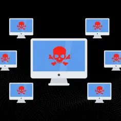 Komputery z czerwonymi czaszkami na ekranach, symbolizujące atak DDoS. To pokazuje, jak działa DDoS.
