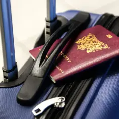 Bagaż gotowy do podróży. Czy do Albanii trzeba mieć paszport? Na walizce leżą dwa paszporty.