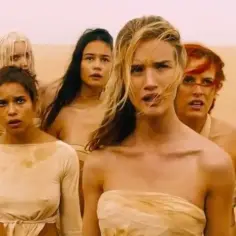 Pięć kobiet z filmu "Mad Max: Na drodze gniewu" stoi na pustyni, ich twarze wyrażają niepokój.