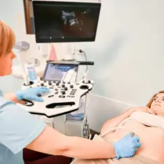 Lekarka wykonuje badania prenatalne w Częstochowie. Pacjentka leży na kozetce, a lekarz wykonuje USG.