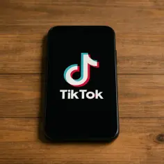 Smartfon z logo TikToka na czarnym ekranie. Chcesz wiedzieć, jak zainstalować TikToka? To proste!