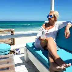 Kobieta z drinkiem na plaży w Tunezji. Czy Tunezja jest bezpieczna dla kobiet? Tak, można tu odpoczywać.