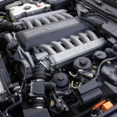 Silnik V12 BMW z widocznym logo i kolektorami dolotowymi.
