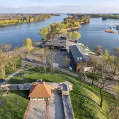 Widok na jezioro i ruiny zamku w Złotnikach Kujawskich. W oddali widać miasto i żaglówki.