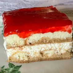 Pyszne, mega szybkie ciasto bez pieczenia z warstwami biszkoptu, kremu i galaretki truskawkowej.