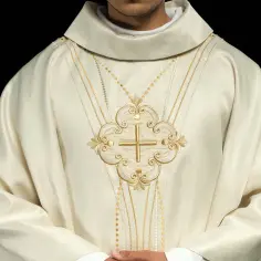 Biała szata z haftowanym złotym krzyżem i ozdobnymi sznurami, symbolizująca liturgia męki pańskiej.