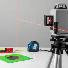 Poziomica laserowa z czerwonymi liniami, miarką, tarczą celowniczą i poziomicą libellową.