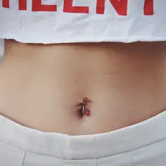 Kolczyk w pępku z czerwonymi kryształkami. Dowiedz się, jak pielęgnować kolczyk w pępku, by był zdrowy i lśniący.
