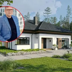 Mężczyzna w garniturze na tle nowoczesnego domu. Informacje o koszt budowy domu 220m2.