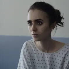 Lily Collins w szpitalnej koszuli, w kadrze z jednego z jej poruszających filmów.