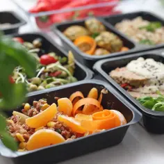 Różnorodne dania w pudełkach, od sałatek po mięso z ryżem i owocami. Zastanawiasz się, ile kosztuje dieta pudełkowa?