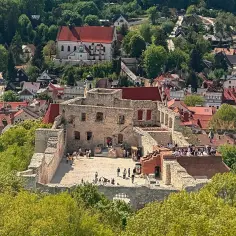 Ruiny zamku w Kazimierzu Dolnym, malowniczo położone wśród zieleni, ukazują, gdzie leży Kazimierz Dolny, miasteczko z urokliwą architekturą.