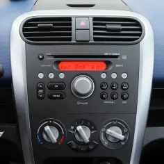 Panel radia i klimatyzacji w Oplu Agila. Czerwony wyświetlacz radia pokazuje "FM1 RMF FM".