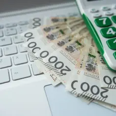 Kalkulator i banknoty 200 zł na klawiaturze. Obliczanie kwoty darowizny wolnej od podatku.