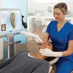 Dentystka wykonuje cyfrowy wycisk zębów pacjentki. Poznaj cyfrowy wycisk zębów cena i nowoczesne metody leczenia.