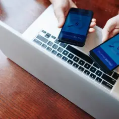 Dwie dłonie trzymają telefony z aplikacją bankową, gotowe do płatności. Szybkie przelewy jak paypal blik.