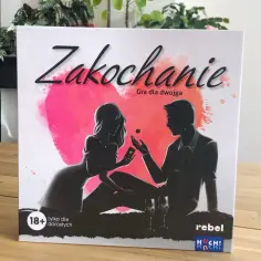 Zakochanie gra dla dwojga" - pudełko gry z sylwetkami pary, sercem i kieliszkami.