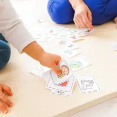Dzieci bawią się kartami z literami i obrazkami, ucząc się słówek. To fajne zabawy edukacyjne.