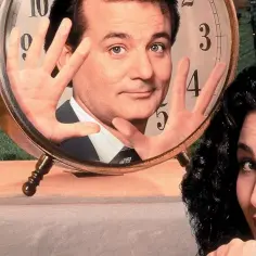 Bill Murray i Andie MacDowell w kadrze z filmu "Dzień świstaka". Bill Murray patrzy przez zegar, a Andie MacDowell zamyśla się.