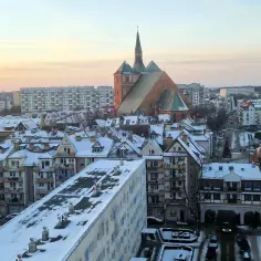 Zimowy krajobraz Kołobrzegu z ośnieżonymi dachami i katedrą. Miasto liczy ok. 45 tys. mieszkańców.