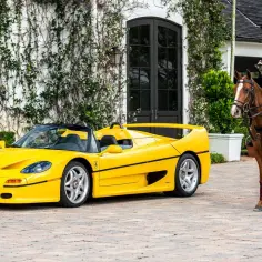 Żółte Ferrari F50 obok gracza polo na koniu.