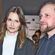 Piotr Adamczyk z żoną, uśmiechnięci, pozują do zdjęcia.