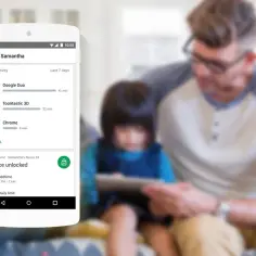 Telefon z Family Link pokazuje aktywność dziecka. Jak wyłączyć Family Link po ukończeniu 13 lat? Rodzic i dziecko patrzą na tablet.