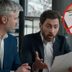 Dwóch mężczyzn analizuje dokumenty. Na pierwszym planie umowa zlecenia przekreślona znakiem zakazu, sugerująca reformę PIP.
