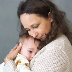 Czuła matka tuli swoje dziecko, łagodząc jego lęk separacyjny u niemowląt.