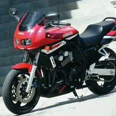 Czerwony motocykl Yamaha FZ1 z czarnym siedzeniem i detalami, zaparkowany na zewnątrz.