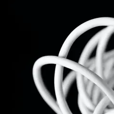 Biały, zwinięty kabel antenowy na czarnym tle. Czy kabel antenowy można łączyć? Tak, ale zależy od typu.