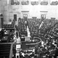 Posiedzenie sejmu w historycznej sali, z licznymi posłami siedzącymi w ławach.