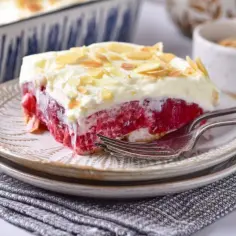 Malinowa chmurka bez pieczenia na herbatnikach, z bitą śmietaną i płatkami migdałów. Idealny deser na gorące dni.