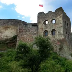 Ruiny zamku w Czorsztynie, z polską flagą na wieży. Warto kupić zamek w Czorsztynie bilety i zwiedzić to miejsce.