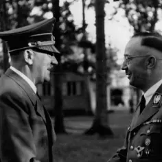 Hitler i Himmler rozmawiają na tle drzew. Na mundurze Himmlera widoczny symbol ss.