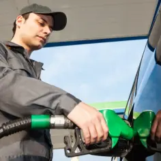 Pracownik stacji paliw tankuje auto. Zastanawiasz się, ile zarabia pracownik stacji paliw netto?