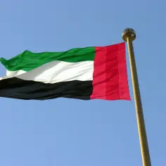Flaga Zjednoczonych Emiratów Arabskich powiewa na tle błękitnego nieba. To kraj, który fascynuje.