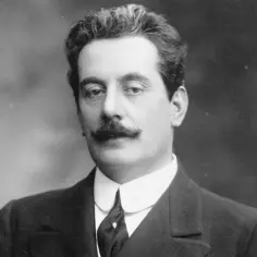 Giacomo Puccini, kompozytor słynnych oper, z charakterystycznym wąsem i eleganckim ubiorem.