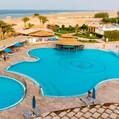 Basen w Concorde Moreen Beach Resort & Spa, z palmami i plażą w tle.