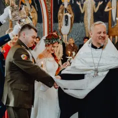 Ceremonia ślubna: czy pop może mieć żonę? Kapłan błogosławi parę młodą, która trzyma świece.