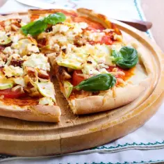 Pizza dla cukrzyka z kurczakiem, cukinią i fetą, ozdobiona bazylią. Zdrowa i smaczna alternatywa dla tradycyjnej pizzy.