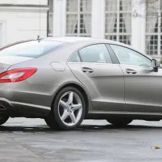 Elegancki, szary Mercedes CLS 350 CDI w218 z polskimi tablicami rejestracyjnymi WW 3893P, zaparkowany przed budynkiem z białymi oknami.