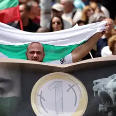 Mężczyzna z bułgarską flagą, pytający "czy Bułgaria jest w Unii?". Na transparencie widnieje oko i lew.