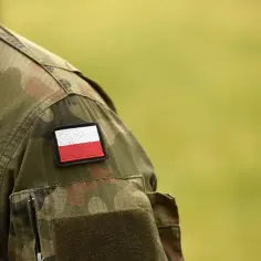 Fragment munduru żołnierza z naszywką z polską flagą. Symbol gotowości do służby, może oznaczać pobór do wojska.