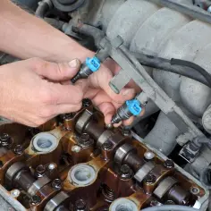 Mechanik wymienia wtryskiwacze podczas czyszczenia układu paliwowego diesel.